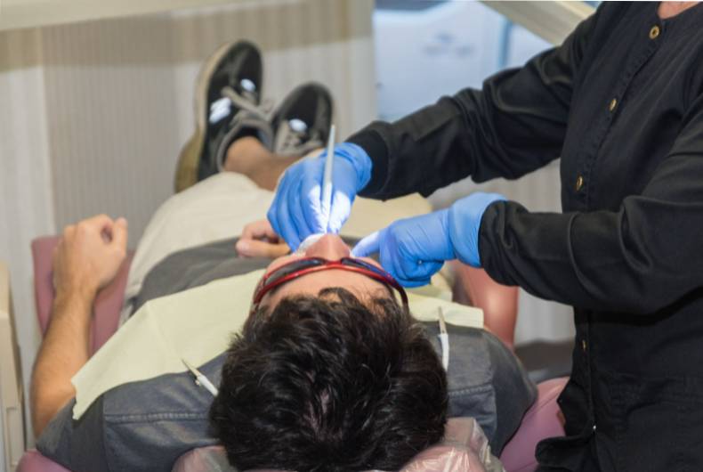 A man getting his teeth checked by an eye doctor.